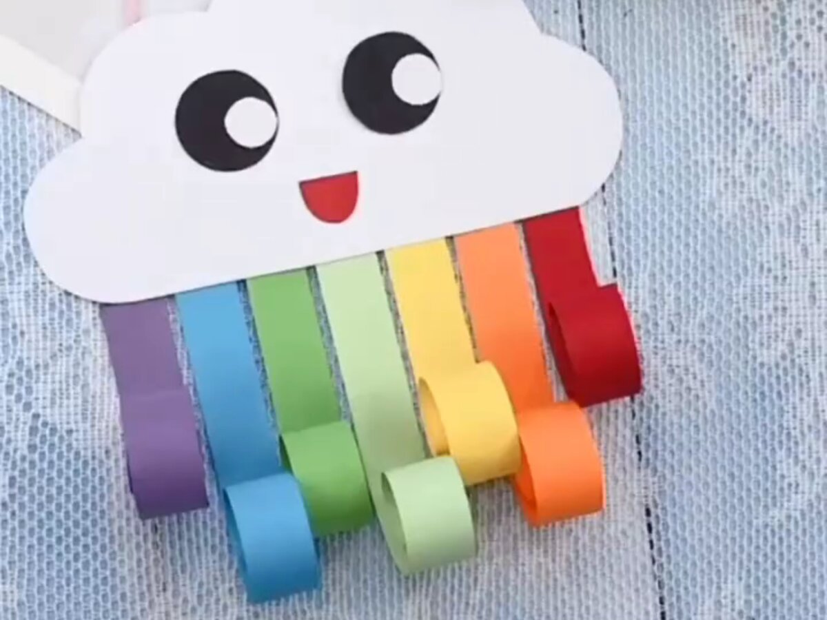 Un nuage en papier avec un arc-en-ciel de bandes enroulées au crayon — Nuage arc-en-ciel pour les 3 à 11 ans en colonie de vacances et en accueil de loisirs