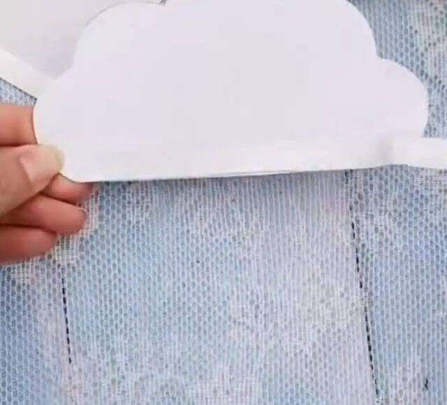 Le gabarit du nuage découpé dans du papier blanc, base du bricolage de nuage arc-en-ciel à accrocher à la fenêtre